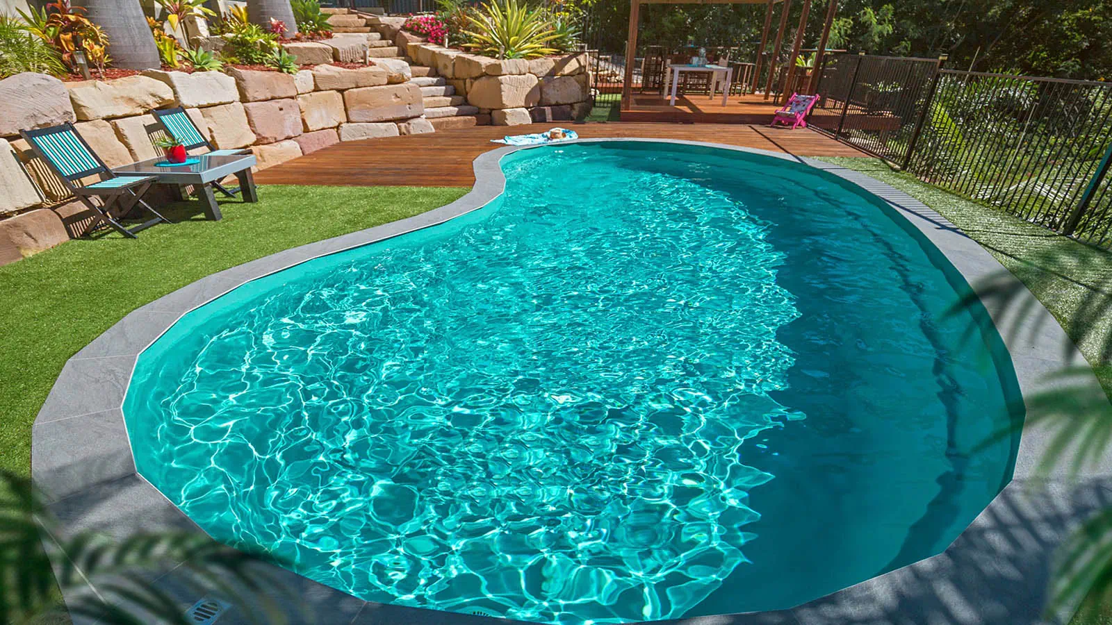 A Leisure Pools backyard pool in Aquamarine color